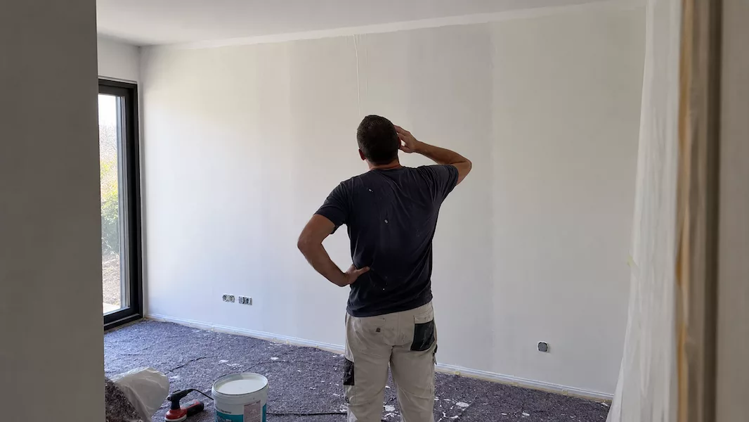 Concrètement, sur des chantiers de maison neuve récents confiés à Nicolas Claude Peinture, portant sur 350 à 500 m² de murs et plafonds avec ponçage des joints, protection des sols et des menuiseries, et pose de plusieurs portes, le budget total se situe le plus souvent entre 5 800 et 6 200 € HT, soit environ 7 000 à 7 400 € TTC, fourniture de peinture comprise. Ramené au m², cela représente un coût de peinture au m² en maison neuve d'environ 12 à 15 € HT tout compris — préparation, protections, application et fourniture. C'est cette fourchette réelle qu'il faut mettre en face du calcul matériel et temps présenté plus haut : dans bien des cas, l'écart avec un chantier fait soi-même, matériel et temps de travail inclus, est plus faible qu'on ne l'imagine.